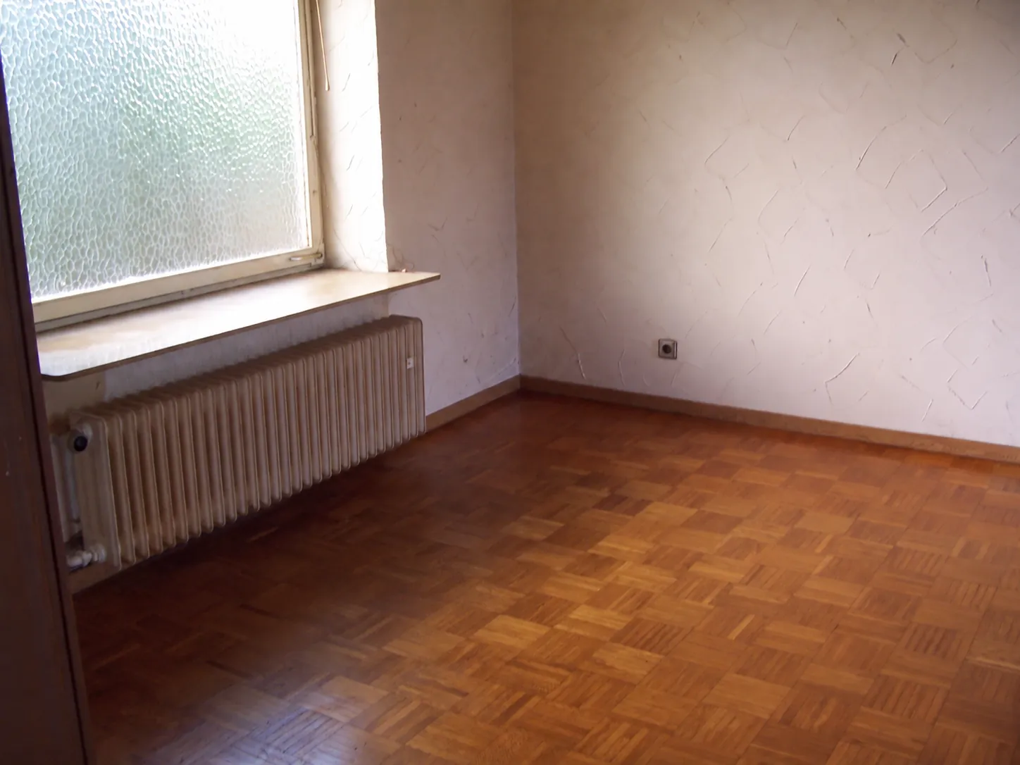 Derselbe Raum nach der Räumung: leer, besenrein, Parkettboden