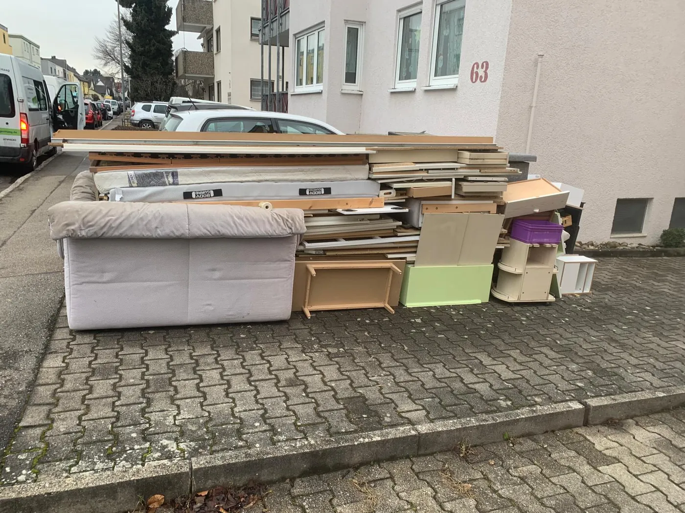 Sofas, Matratzen und Möbel vor einem Wohnhaus bereit zum Abtransport